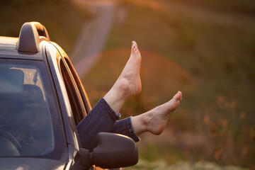 Summer travel concept with legs of a woman and car.
