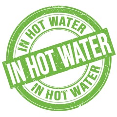 IN HOT WATER text written on green round stamp sign