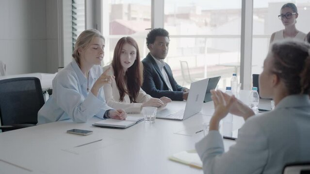 A group of diverse young professionals in a modern office collaborate on corporate strategies and new ideas in a casual atmosphere, focused on brainstorming and innovative solutions