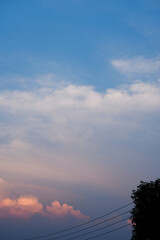 Sky background when a sunset behind the horizon. Background of sky sunset with the colors of white, blue, and orange. Vertical image of evening sky and clouds at the end of the day. Scene and nature.