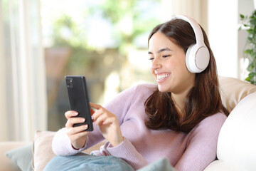 Happy woman with headphone and smart phone watching media