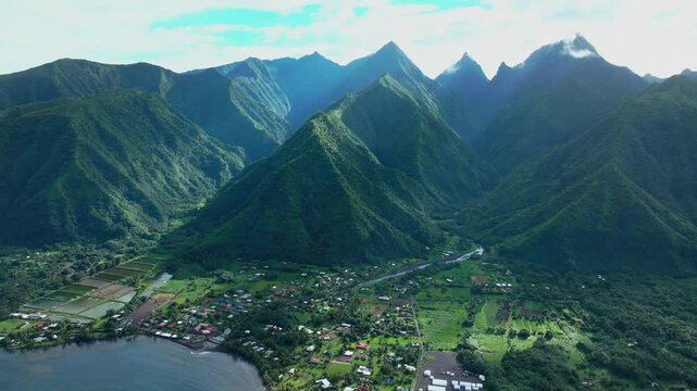Teahupoo Tahiti French Polynesia aerial drone daytime sunny green island mountain peaks  town village Paris summer Olympics venue Mount Orohena Aorai Ronui blue sky river valley circle left
