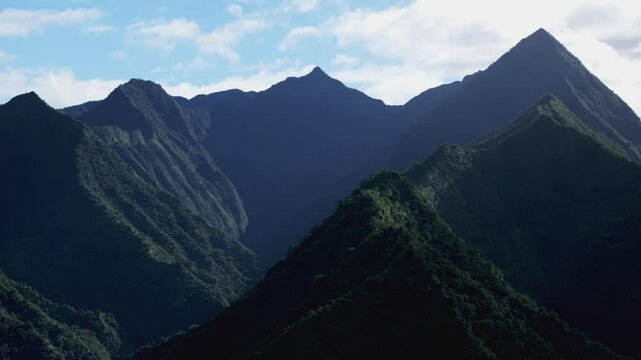 Green volcano island mountain peaks Teahupoo Tahiti French Polynesia aerial drone sunny morning shade town village Paris summer Olympics venue Mount Orohena Aorai Ronui blue sky valley forward