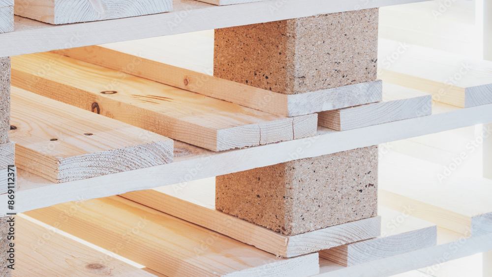 Poster A stack of wooden pallets with a brick base. The pallets are stacked on top of each other, creating a sturdy base. Concept of strength and durability