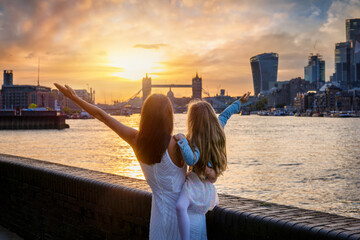 A mother and her daughter looking at the skyline of London, England, during a beautiful summer sunset