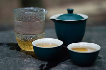 Tea ceremony in the forest. Ceramic blue teapot and tea cups