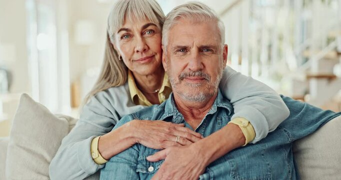 Mature couple, face and hug on sofa for love, marriage, and support with security or comfort on break or holiday. Portrait of man and woman in living room with embrace, bonding and together at home