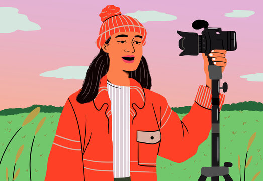 Young woman recording vlog with DSLR camera during sunset in park