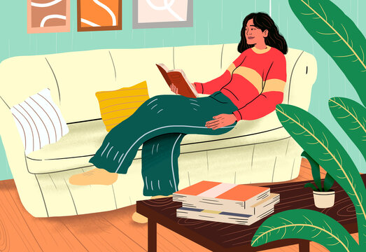 Woman reading book and lying on sofa at home