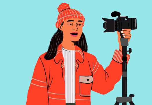 Smiling woman holding camera on tripod against blue background