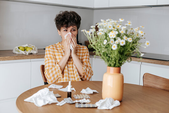 Woman with flower allergy in kitchen at home