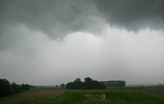 Storm clouds over polder with old bunker