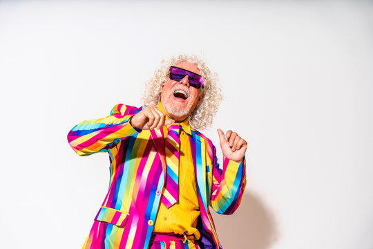 Cheerful senior man dancing against white background