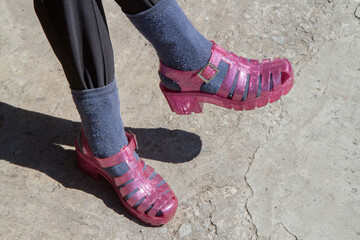 The woman's feet are in pink shoes and socks.
