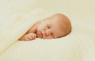 Portrait of sweet baby, infant sleeping lying on white bed at home