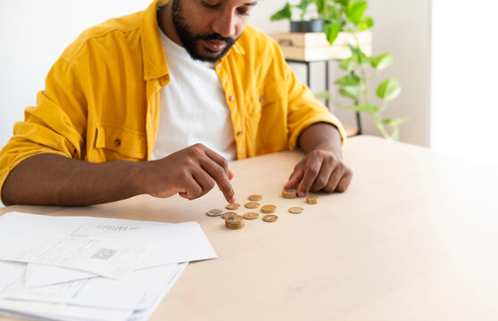 Young man counting coins to pay bills