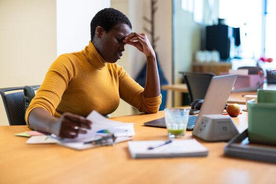 Frustrated businesswoman sitting at desk in office
