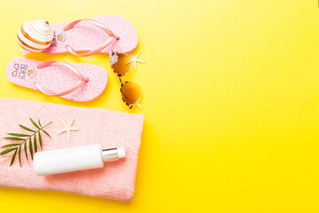 Summer holiday concept. Top view of beach towel, flip flop and sunscreen cream on table Top view...