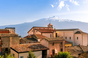 Obraz premium scenic view from a beautiful italian town to amazing buildings with church and roofs and picturesque highland mountain with nice blue cloudy sky on background