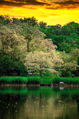Sunset over the river . Another river beach. May and trees . Green colors . Reflections on water . Fising on river . Golden sunset 