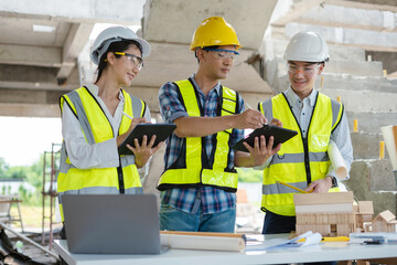 civil engineer and worker discussing issues at the construction site in the morning.