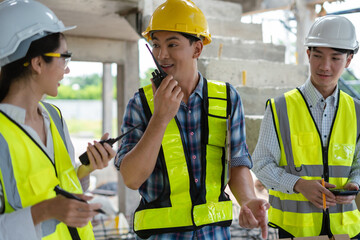 civil engineer and worker discussing issues at the construction site in the morning.