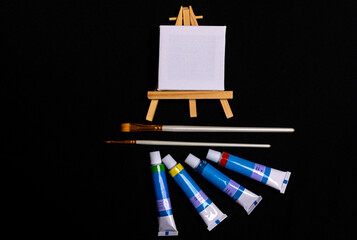 Eine Staffelei für einen Künstler mit Pinseln und Farbtuben.