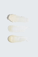 A detailed close-up of three skincare textures, featuring a creamy exfoliant, a smooth moisturizer, and a luxurious cream. Perfect for showcasing beauty routines and cosmetic products in high-quality