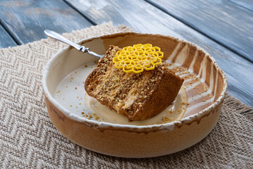 Honey cake, medovik layered dessert, sponge honey biscuit piece with white cream, gingerbread cut closeup
