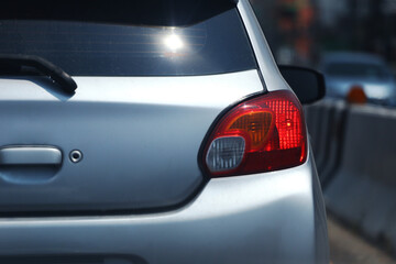 Red lights on the back of a bronze-colored sedan while the engine was turned off .