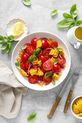 Tomato and corn salad with fresh basil, onion, dressed with olive oil. Mexican food, tomato corn salad Esquites, top view