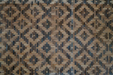 Wall made of woven bamboo in a square pattern, showcasing traditional craftsmanship and natural materials.