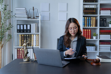 A female attorney is diligently working at her desk in the office.