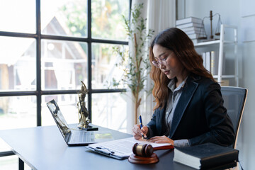 A female attorney is diligently working at her desk in the office.