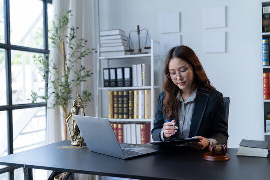 A female attorney is diligently working at her desk in the office.