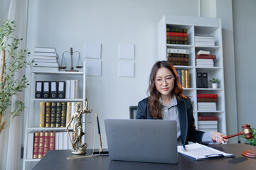 A female attorney is diligently working at her desk in the office.