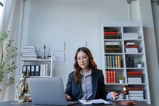 A female attorney is diligently working at her desk in the office.