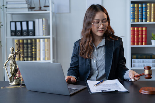 A female attorney is diligently working at her desk in the office.