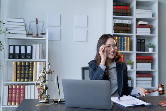 A female attorney is diligently working at her desk in the office.