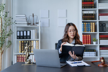 A female attorney is diligently working at her desk in the office.