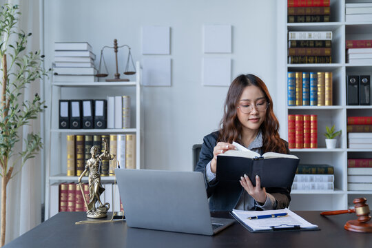 A female attorney is diligently working at her desk in the office.