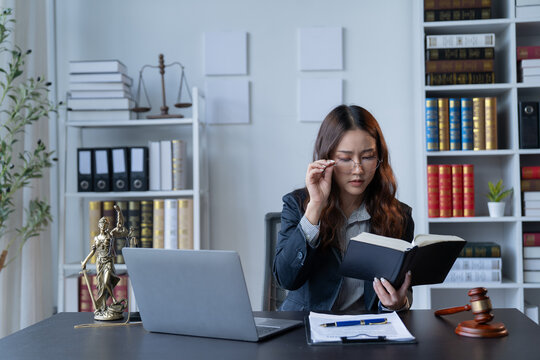 A female attorney is diligently working at her desk in the office.