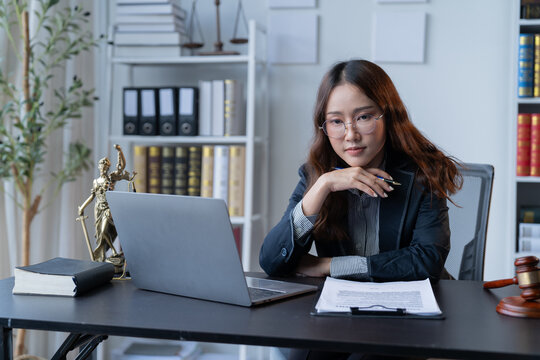 A female attorney is diligently working at her desk in the office.