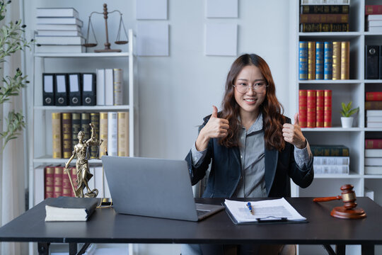 A female attorney is diligently working at her desk in the office.