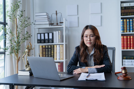 A female attorney is diligently working at her desk in the office.