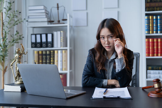 A female attorney is diligently working at her desk in the office.