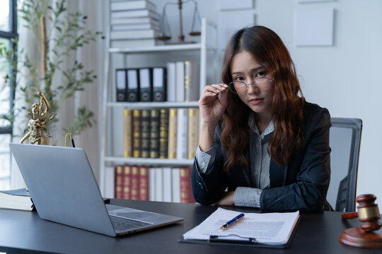 A female attorney is diligently working at her desk in the office.