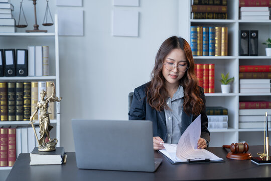 A female attorney is diligently working at her desk in the office.