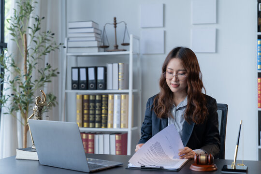 A female attorney is diligently working at her desk in the office.