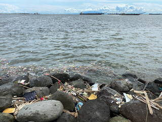 Ocean debris has washed up on the rock breakwater